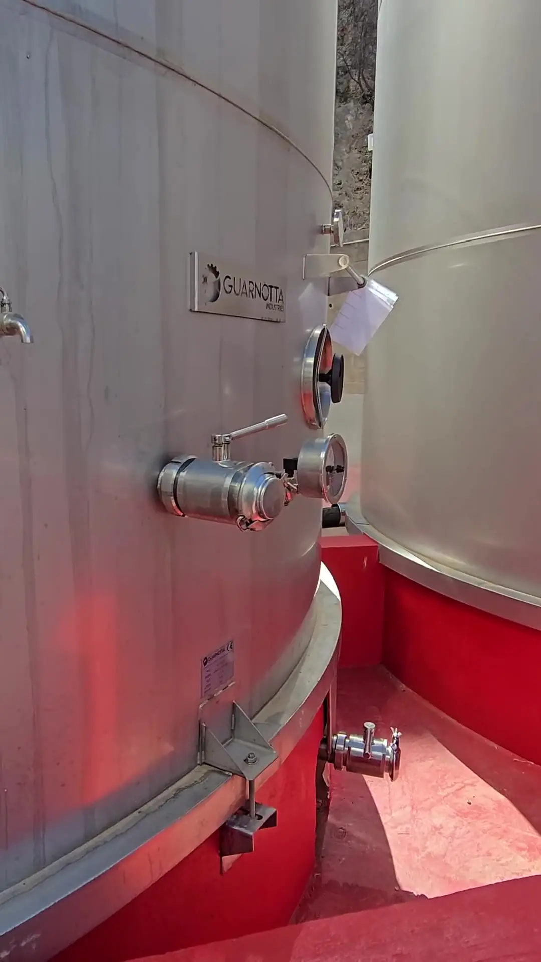 Valvole di scarico con attacchi inox alla base di un serbatoio per il vino