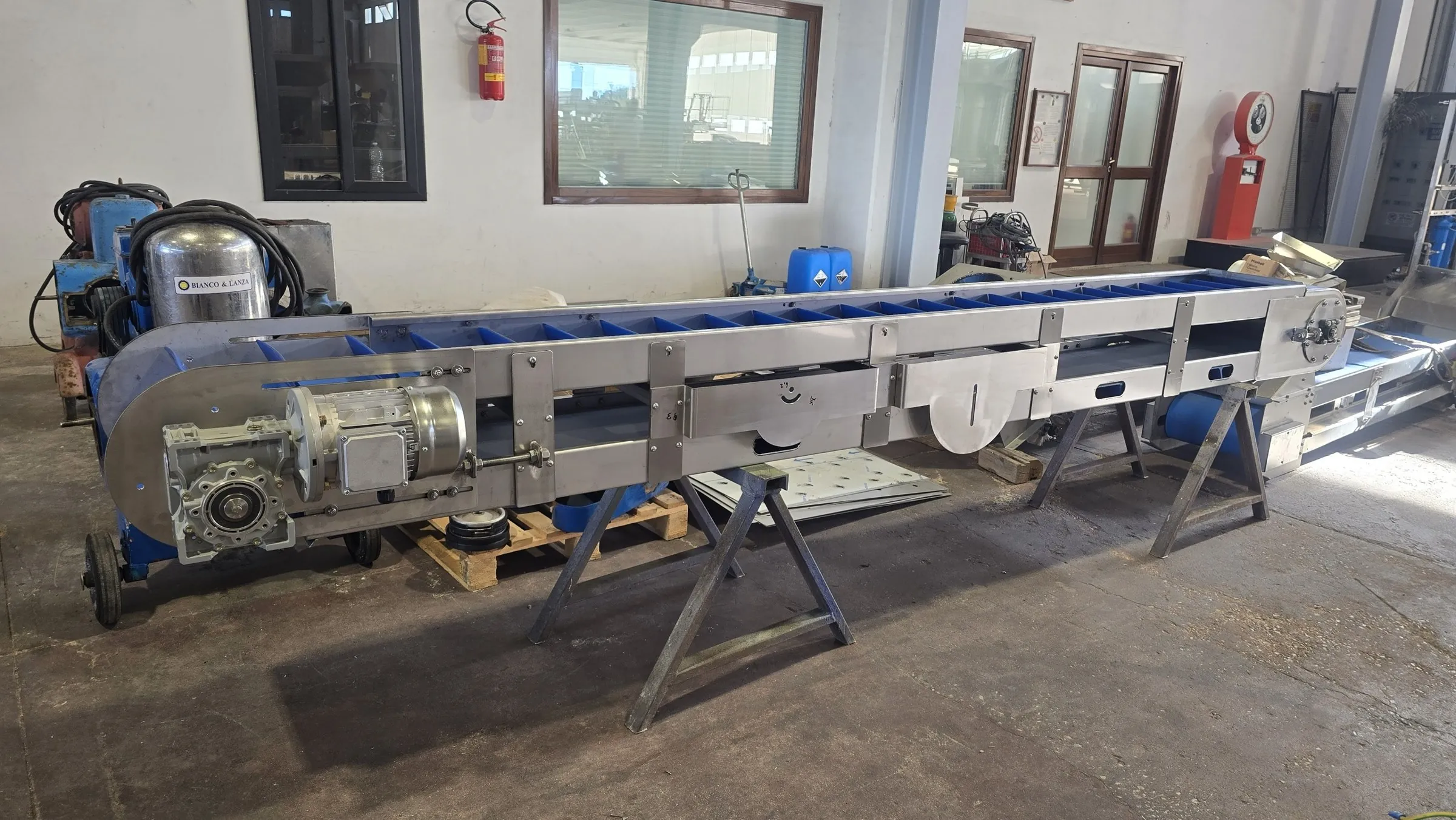 Guarnotta conveyor belt, fully enclosed with stainless steel sides, blue cleated belt and side-mounted gearmotor