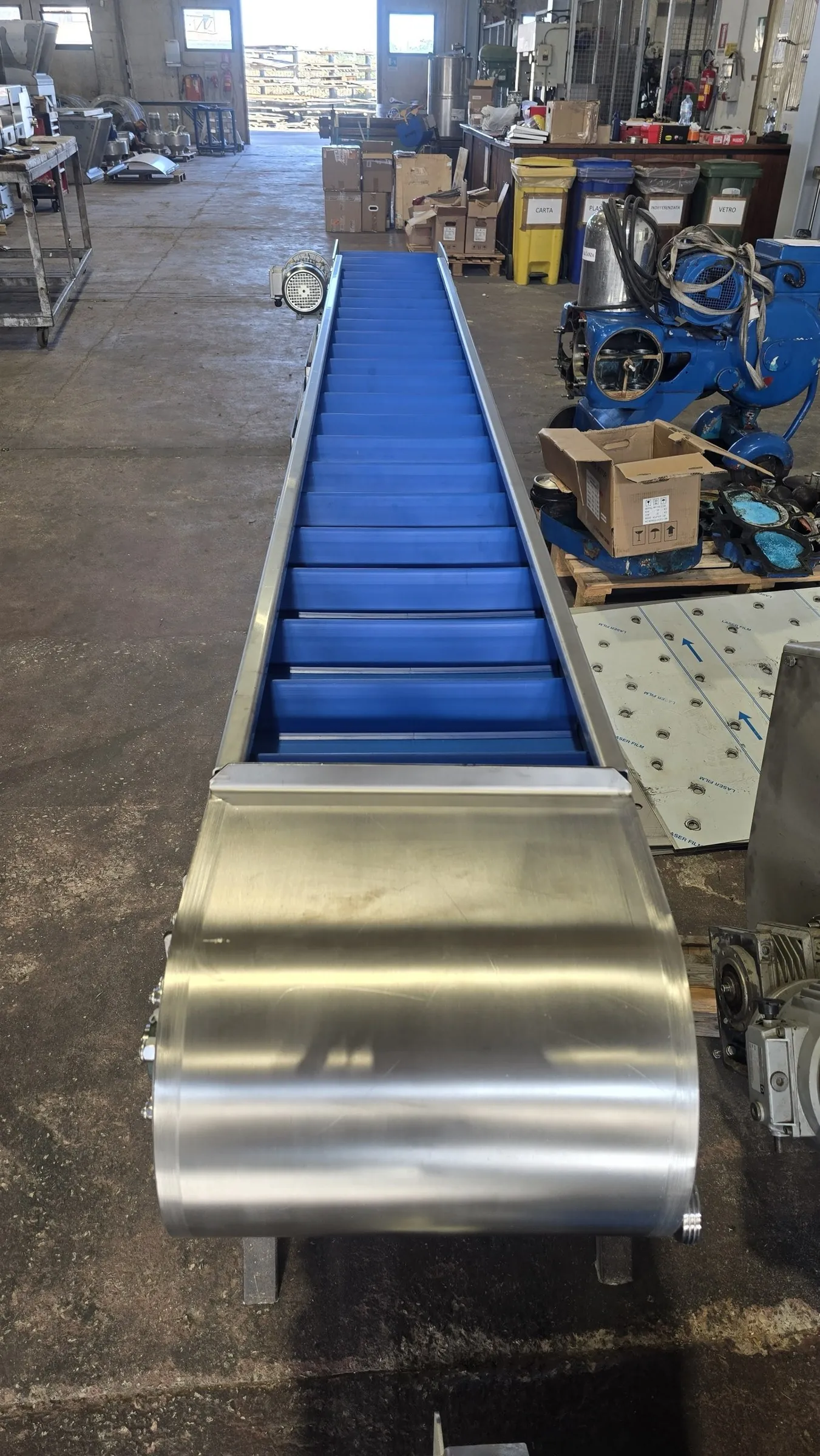 Tail of the conveyor with its stainless steel guard, looking along the cleated belt