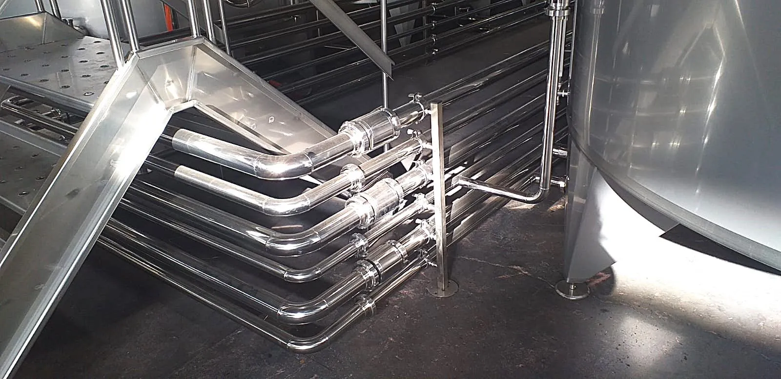 Tubazioni inox affiancate tra i serbatoi