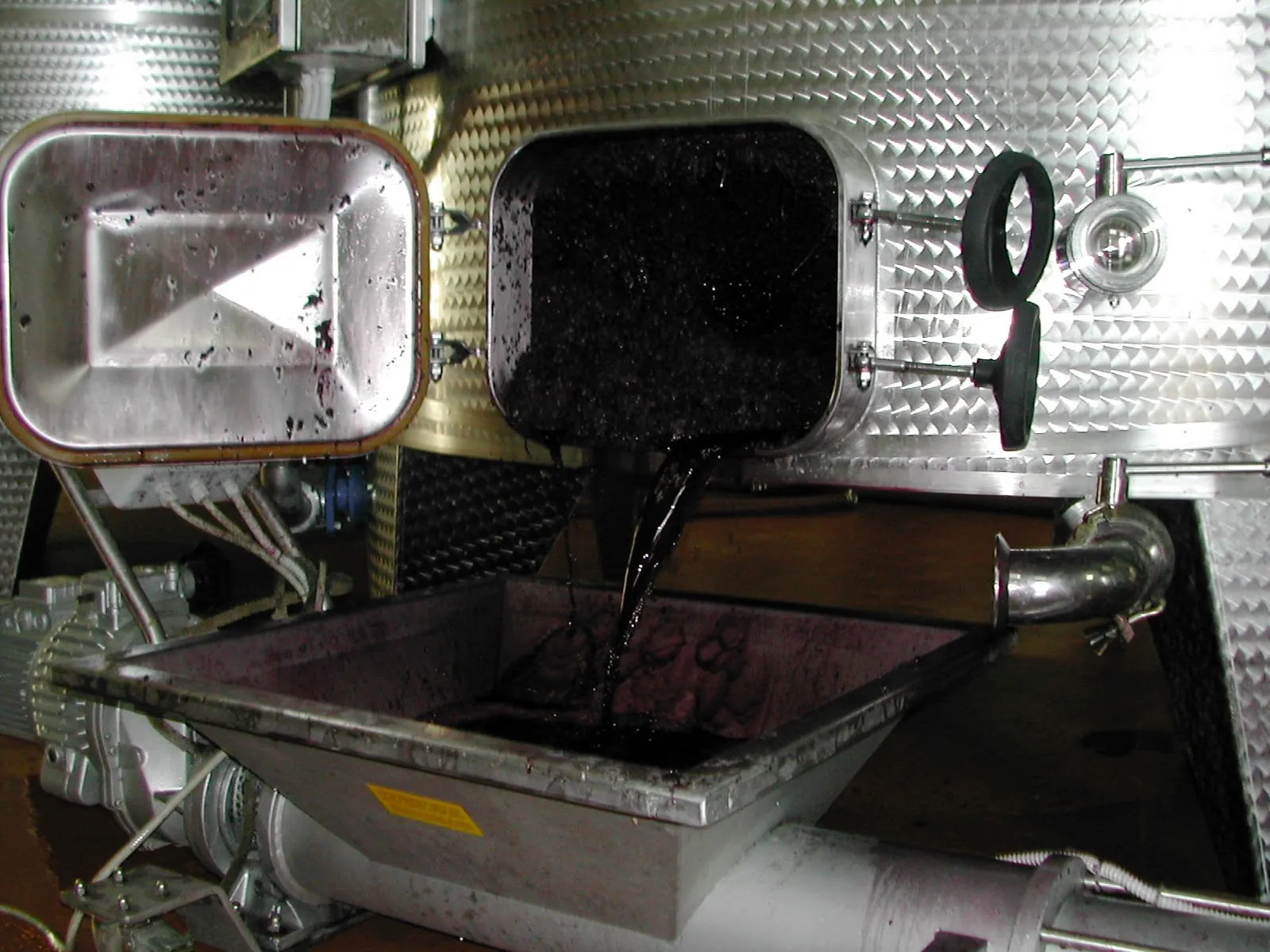 Estrazione delle vinacce dalla portella di un vinificatore